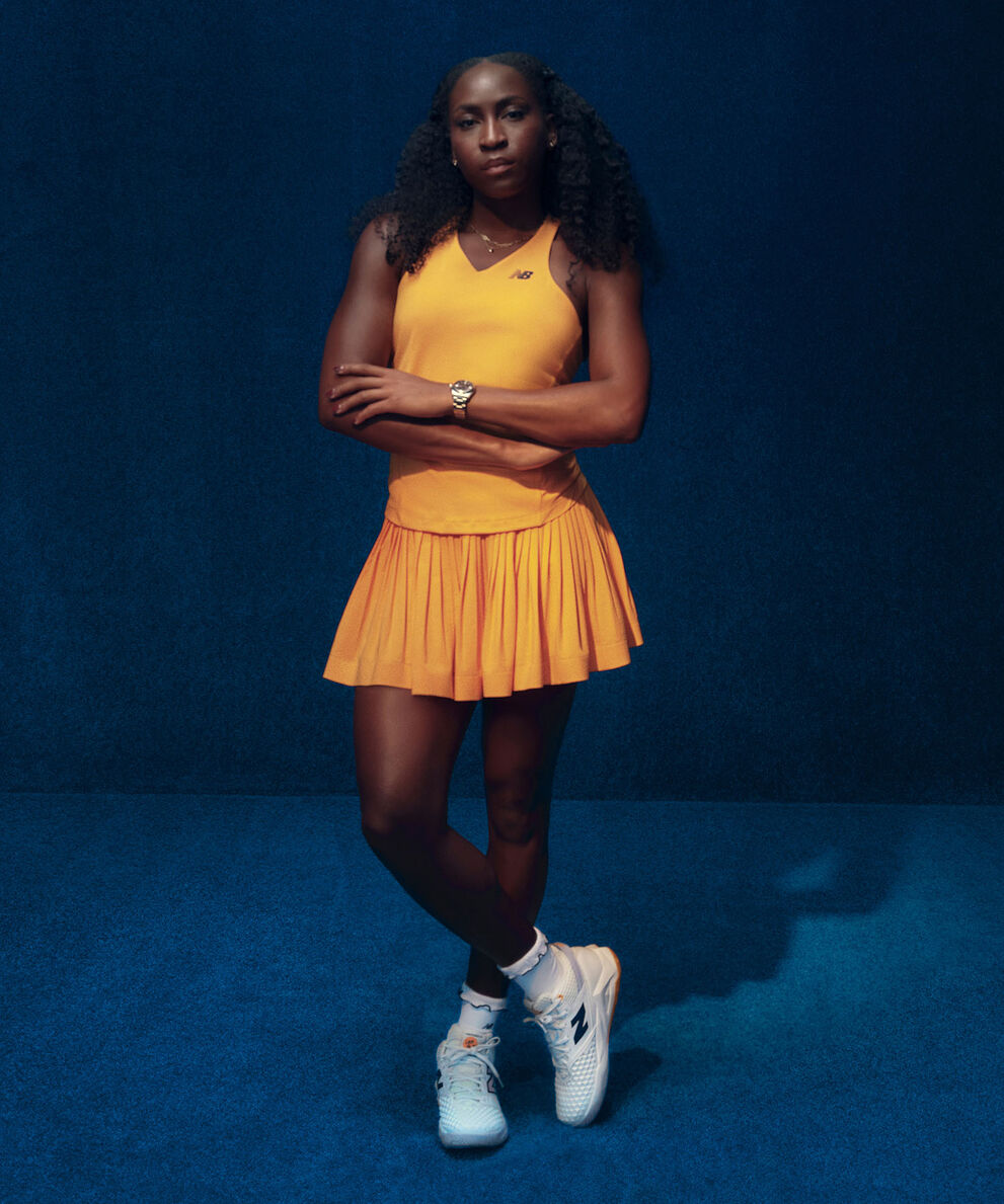 Coco Gauff standing in front of a dark blue studio backdrop.
